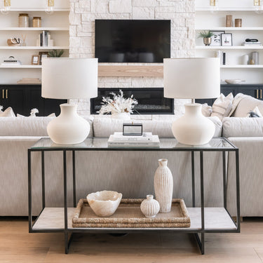 Modern living room with a console table, vases, and a fireplace.